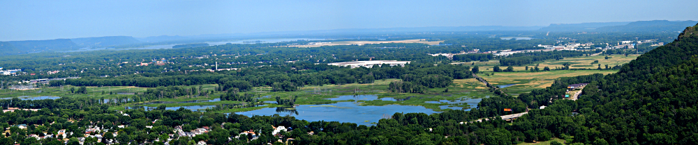 [Partially zoomed-in view of the lakes and trees sitting just north of LaCrosse. The edge of one bluff is visible on the right side of this panoramic images (several photos stitched together).]